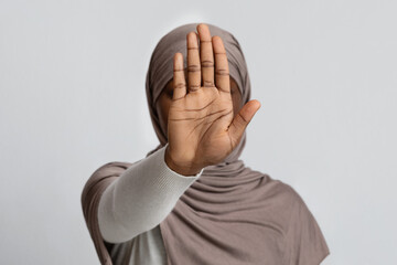 No Discrimination. Black lady in hijab showing stop gesture with open palm