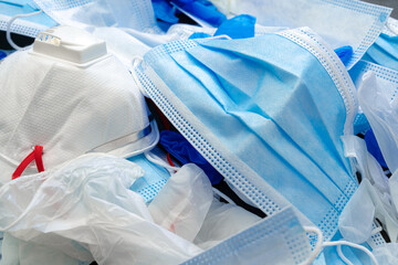 Coronavirus protection equipment in medical waste bin. Used face masks and sterile gloves.