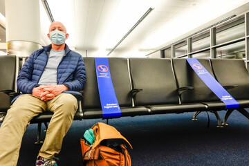 Boston Massachusetts, USA A man sits in the departure terminal at Loga aiport with social distance...