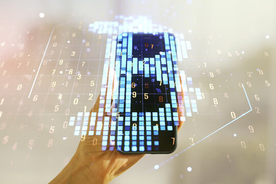 Double exposure of creative Bitcoin symbol hologram and hand with cellphone on background. Mining and blockchain concept