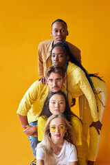 students from different countries in studio with yellow background, mixed race people in one group,...