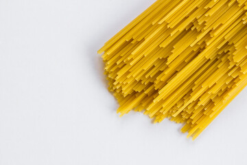 Uncooked, raw, traditional  spaghetti stripes,pasta sticks on white with copy space
