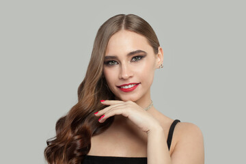 Beautiful smiling woman with brown curly hair and red manicure nails on white background