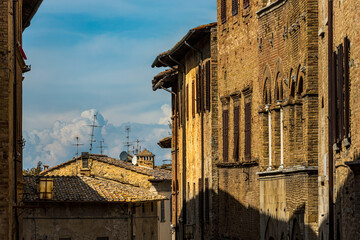 Häuserreihe mit Fernsehantennen in einer Gasse von San Gimignano in der Toskana, Italien