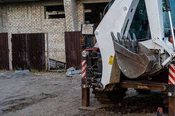 Fototapeta na wymiar Old tractor standing near building construction