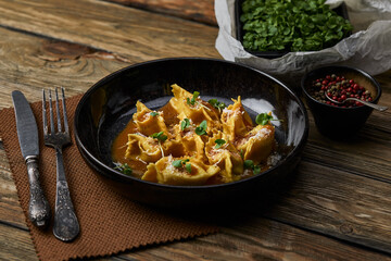 Italian ravioli stuffed with meat closeup on a black plate. rustic style