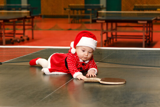 Six-month-old baby girl and table tennis racket for Christmas.