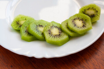 Slices of ripe kiwi on a white plate