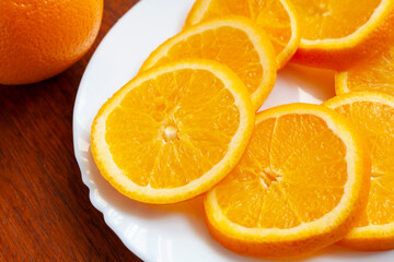 Slices of ripe orange on a plate on the table