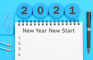 2021 New Year New Start written on a diary on blue background
