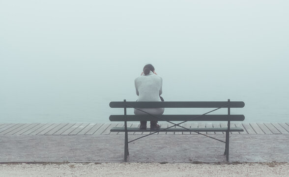 Depressive Frau auf Bank sitzend.