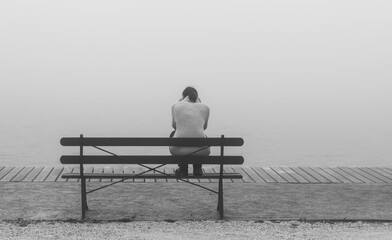 Depressive Frau auf Bank sitzend.