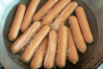 Hotdog is boiling in a pot.