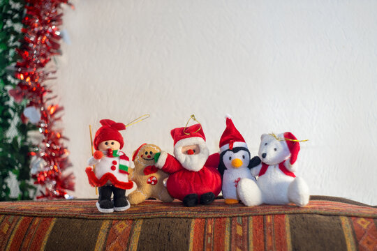 some little christmas figures on top of a chair waiting for a happy new year they are a santa claus penguin cookie white bear
