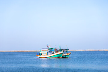 Naklejka premium Fishing boats in the sea on a clear blue sky.