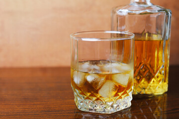 Whiskey with ice on the table close-up, place for your text.