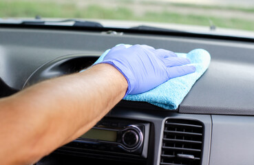 Cleansing car interior. Male hand  in protective glove disinfecting vihicle inside