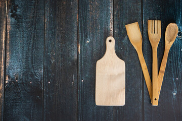 Przybory kuchenne na ciemnych deskach. © andsko