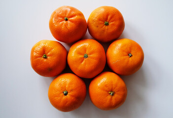 Seven tangerines on white background top view