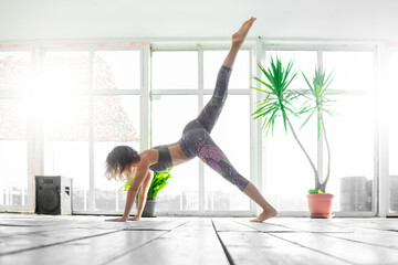 Woman stretching on a indoor SUP board.