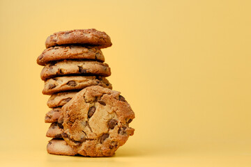 Pile of chocolate chip cookies on yellow backgreound