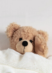 Headache, insomnia. Cute teddy ill laying in bed