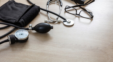 Medical stethoscope and sphygmomanometer on wooden background