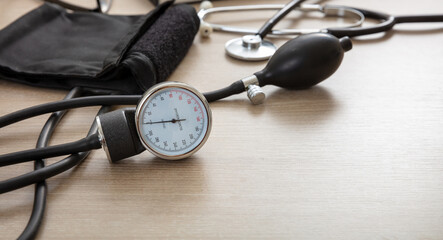 Medical stethoscope and sphygmomanometer on wooden background