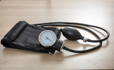 Medical sphygmomanometer on wooden desk, closeup view.