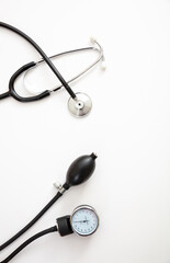 Medical stethoscope and sphygmomanometer on white background, top view.