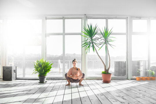 Woman Practicing Garland Pose During Her Yoga Class