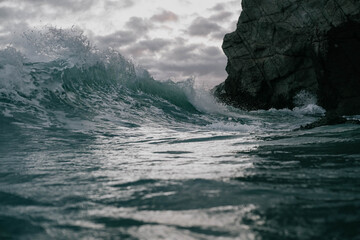 Fototapeta na wymiar blue waves crashing onto rocks 