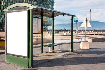 Deserted bus stop with a glass shelter with a blank billboard. Copy space. Reykjavik, Iceland.
