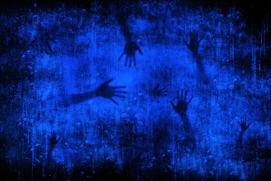 Abstract blurred silhouette of human hands on blue grunge background. Monochrome gothic illustration © zenobillis