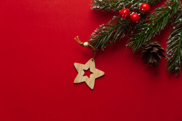 Wooden Christmas tree toy in the form of a star on a red background.