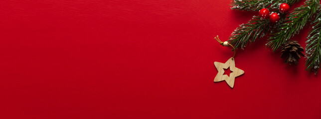 Wooden Christmas tree toy in the form of a star on a red background.