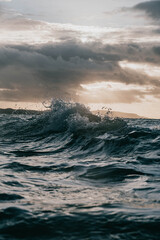 moody waves crash with sun breaking through - obrazy, fototapety, plakaty