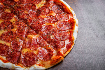 Pepperoni Pizza with Mozzarella cheese, salami, Tomato sauce, pepper, Spices. Italian pizza on wooden table background