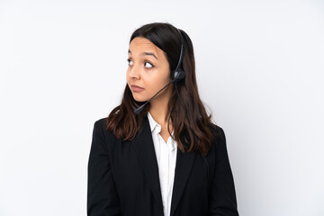 Young telemarketer woman isolated on white background making doubts gesture looking side