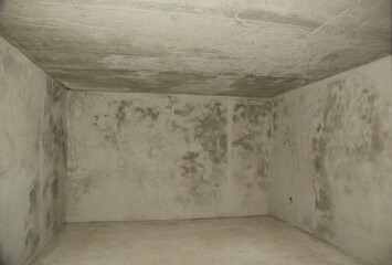 A view of an empty concrete rendered underground basement, cellar, bombproof shelter or nuclear...