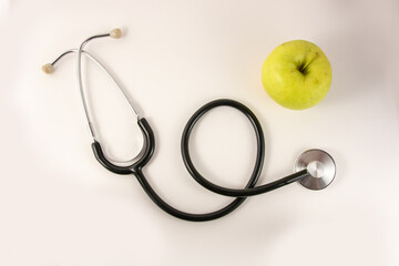 Apple and stethoscope on a white background