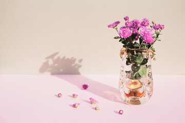 Creative composition made of chrysanthemum flowers in a vase on pastel background.