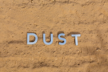the word dust on dusty road surface in flat lay perspective