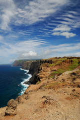 Fototapeta na wymiar Portrait of north coast Molokai sea cliffs with ripple cloud sky