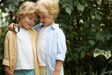 smiling friendly friends boys in the garden, awesome caucasian children look at each other, going to learn the garden and plants together. nature concept