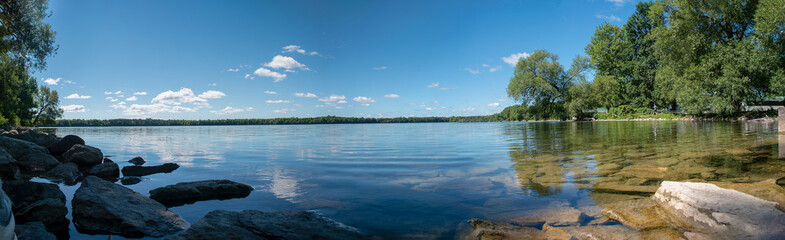 A panoramic view of the crystal clear waters of Lake on a Mountain near Picton in Prince Edward County, Ontario as they glisten in the morning sun on a beautiful late summer day.