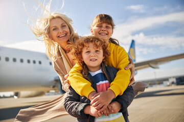 Laughing family is standing outside the plane