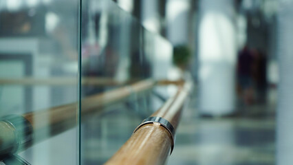 Wooden railings and glass wall in a large shopping center for the comfort of shoppers, modern design.Close-up, selective focus, blur