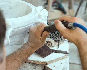 hands of marble sculptor operating pneumatic rock-drill , Carrara, Italy