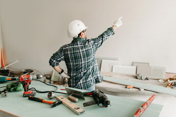 Builder repairman in protective helmet with tools